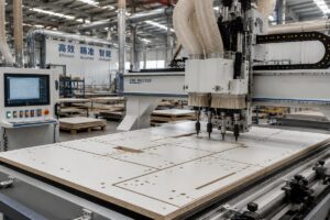 Factory floor with a CNC router running panel nesting and automatic boring operations